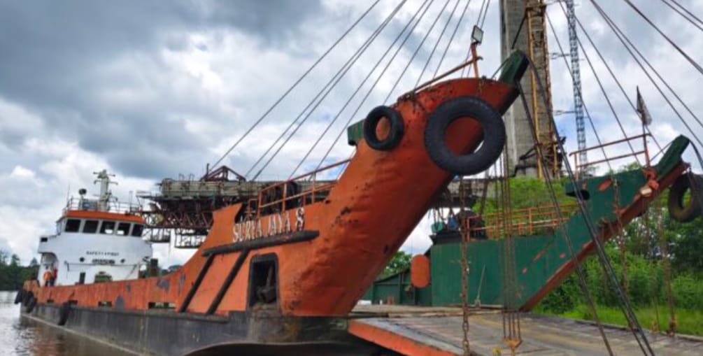 Keterangan: Tongkang pengangkut material batu split tampak bersandar di sekitar Jembatan ATJ Melak, Kutai Barat, dalam aktivitas bongkar muat yang disorot karena diduga berlangsung di luar fasilitas kepelabuhanan resmi. Foto: Istimewa dari media Reportaseexspose.com